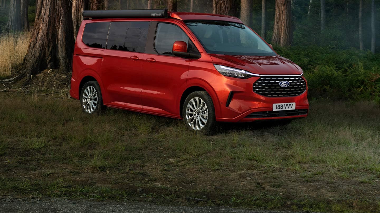 Roter Ford Nugget, parkiert auf einer Wiese im Wald.