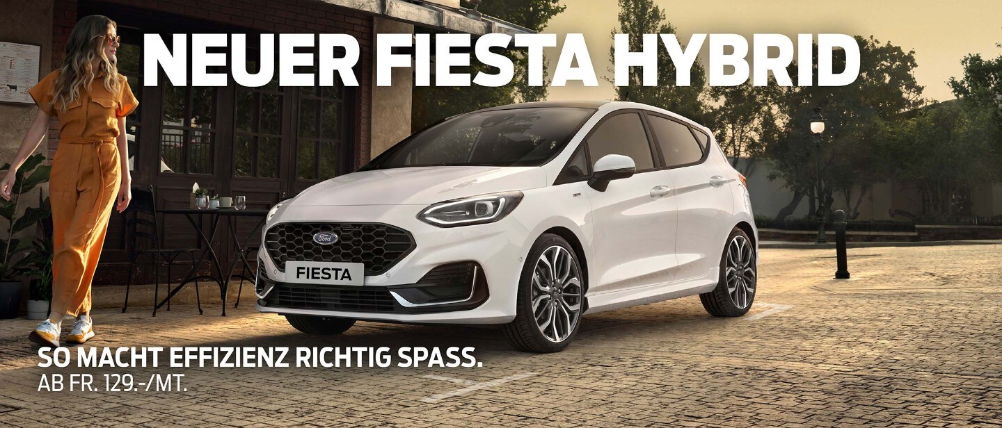 Ford Fiesta in Weiss. Dreiviertel-Frontansicht vor einem Restaurant parkend mit Frau im Vordergrund.