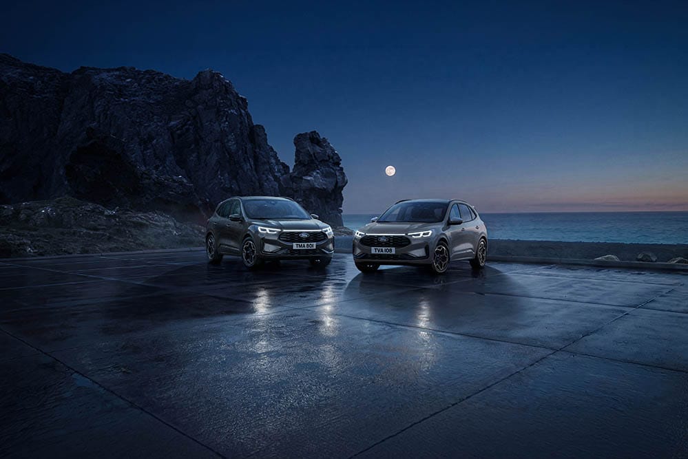 Zwei Ford Kuga parken bei Nacht an der Küste unter dem Vollmond.