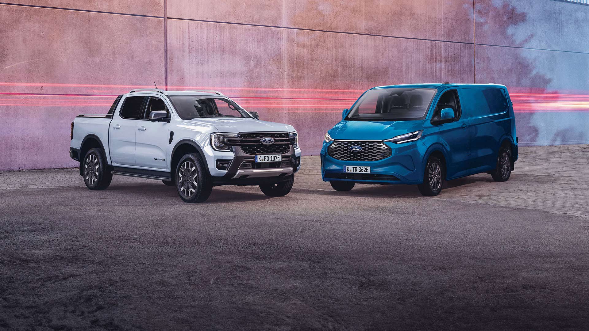 Weisser Ford Ranger und blauer E-Transit Custom nebeneinander geparkt.