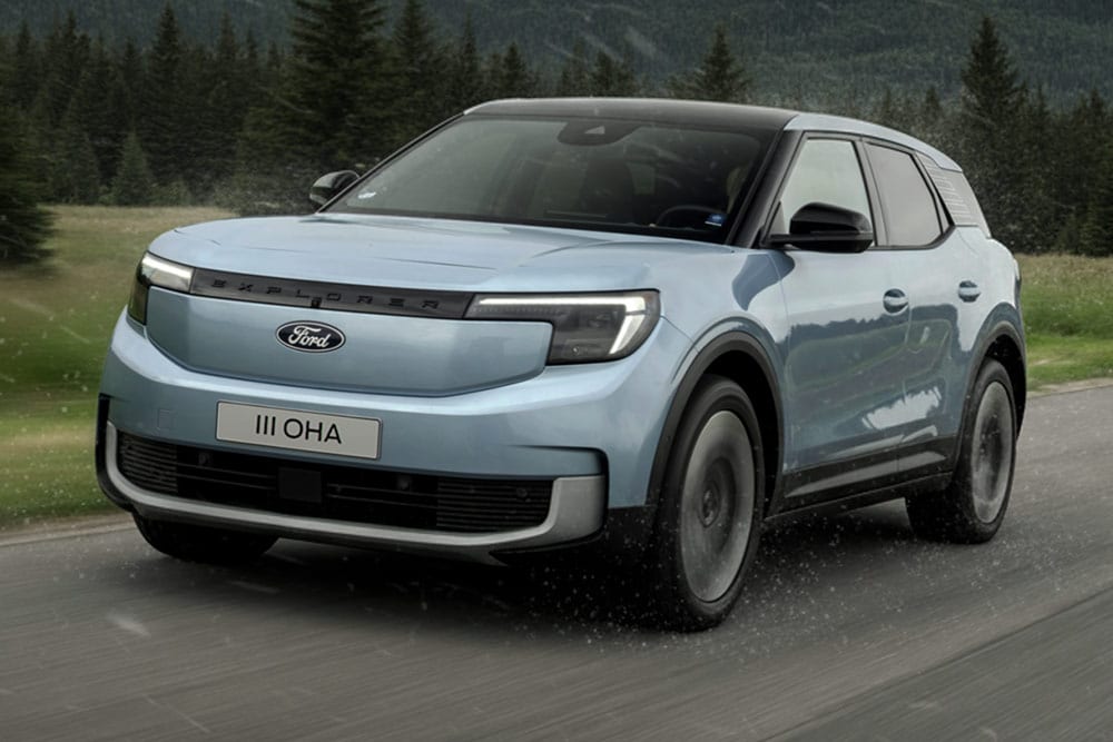 Ford Explorer fahrend auf einer Landstrasse mit Bergen im Hintergrund