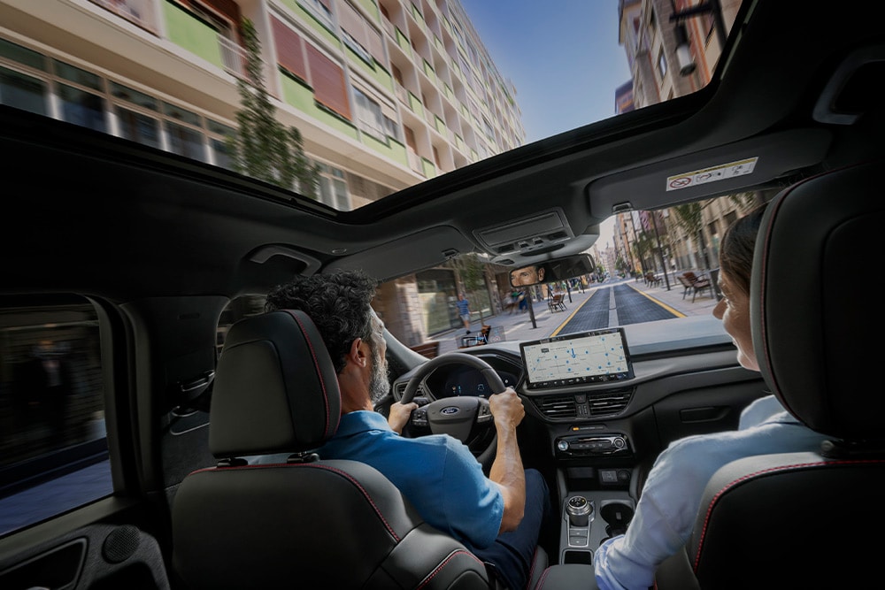 Innenansicht eines Ford Plug-in-Hybridfahrzeugs mit fahrzeugeigener Navigation. 