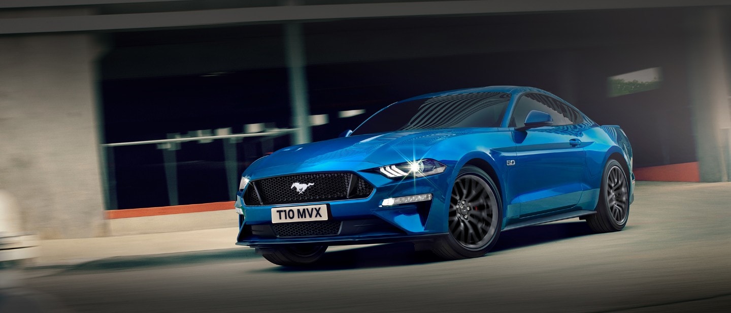 Blue Ford Mustang driving in the city