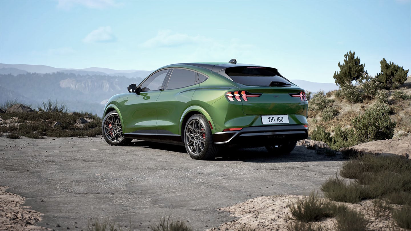 Die Rückseite des grünen Ford Mustang Mach-E GT  parkt auf einer Bergstrasse.