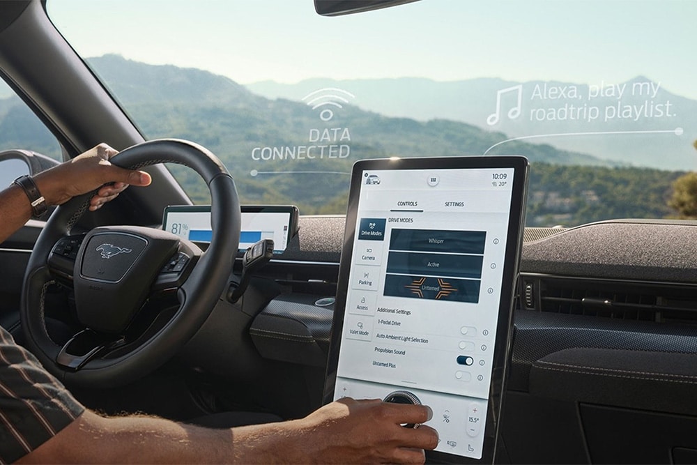 Nahaufnahme des Fahrers eines Ford Mustang Mach-E, der mit dem grossen 15,5-Zoll SYNC 4 Touchscreen interagiert.
