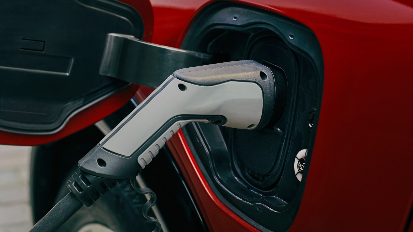 Ford Mustang Mach-E in Rot. Detailansicht Ladeanschluss am Fahrzeug 