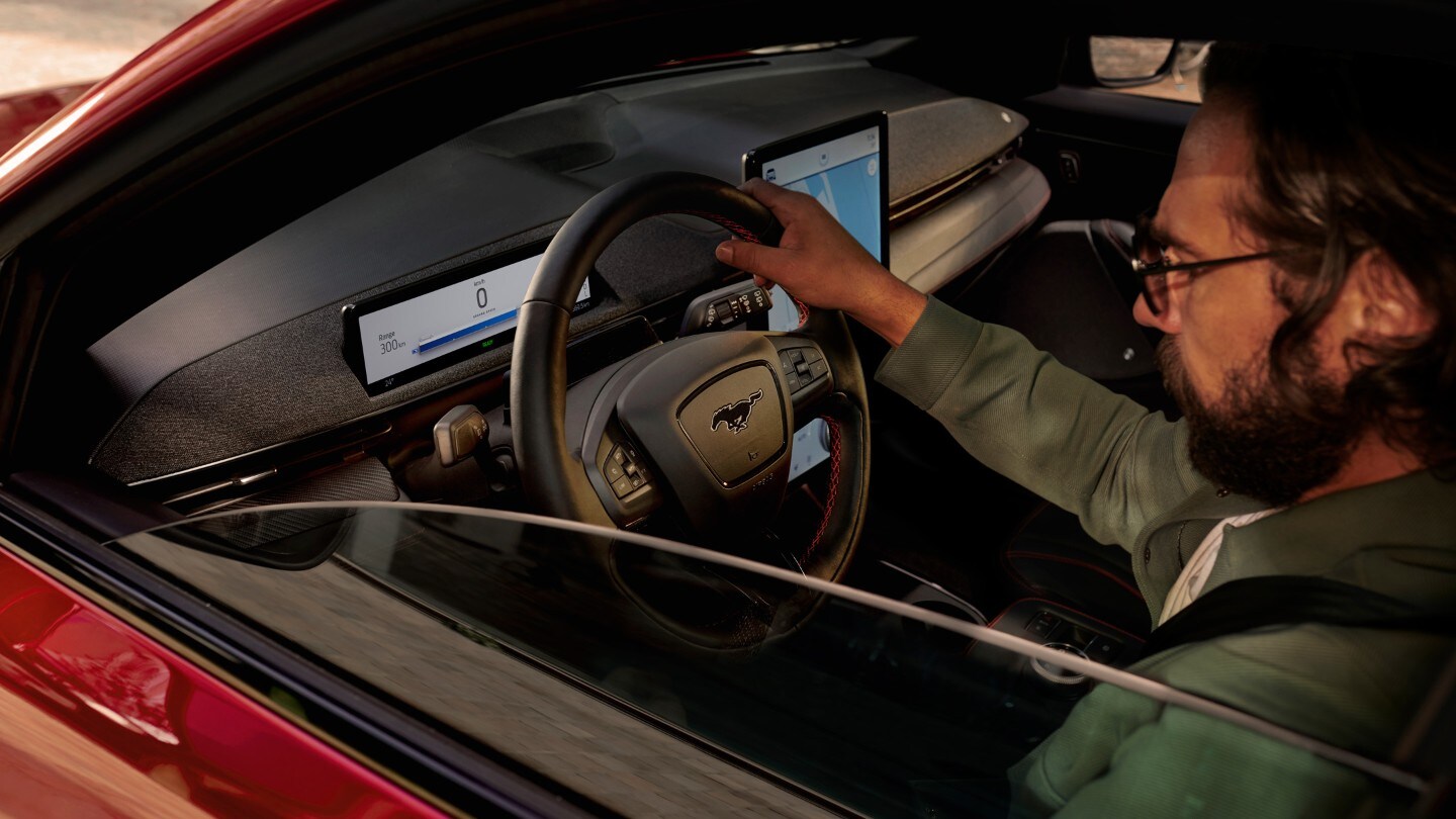 Ford Mustang Mach-E. Blick durch das Seitenfenster auf den Fahrer am Steuer