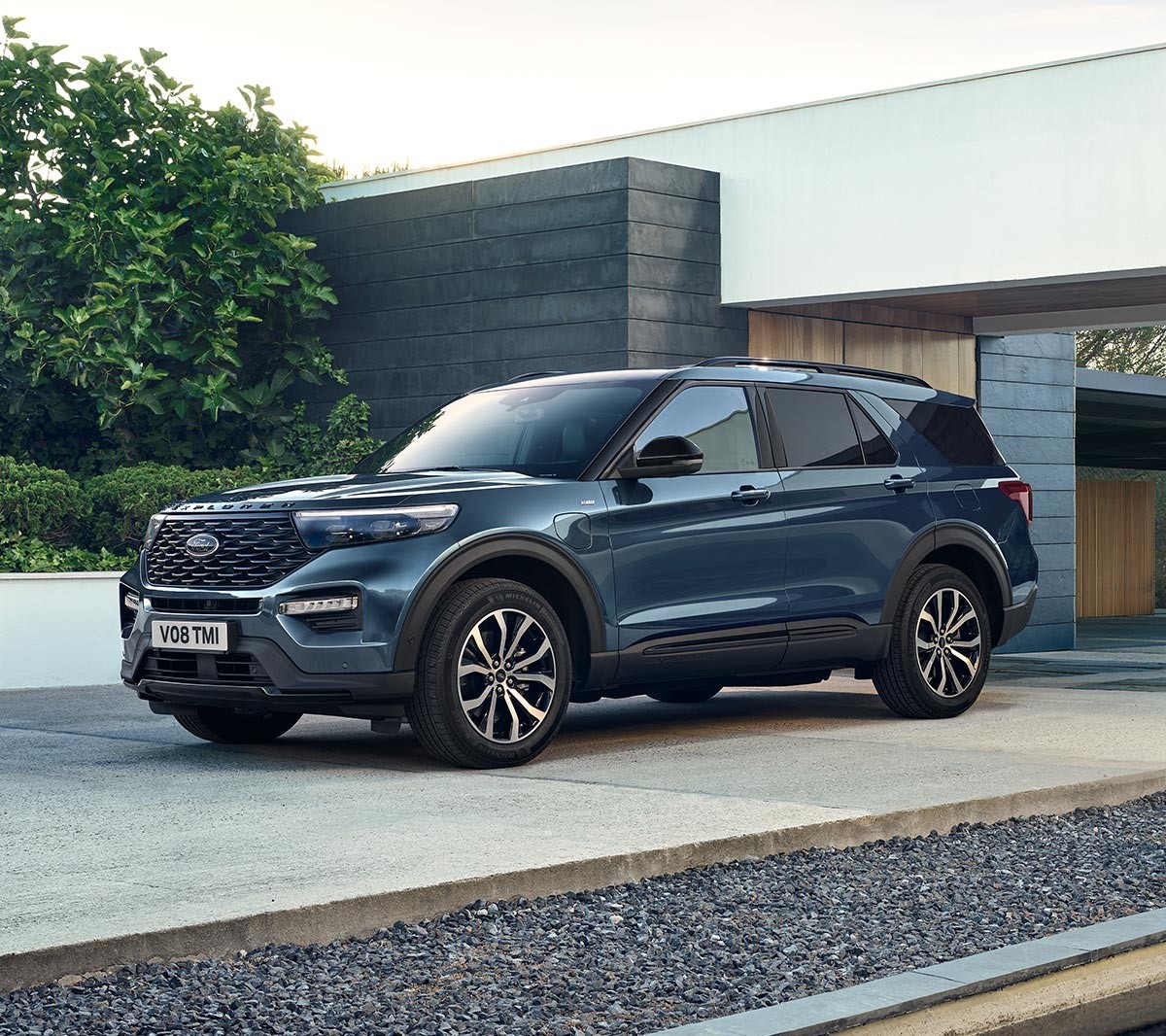 Ford Explorer Plug-In Hybrid in Blau. Dreiviertel-Frontansicht. Vor einem modernen Gebäude parkend