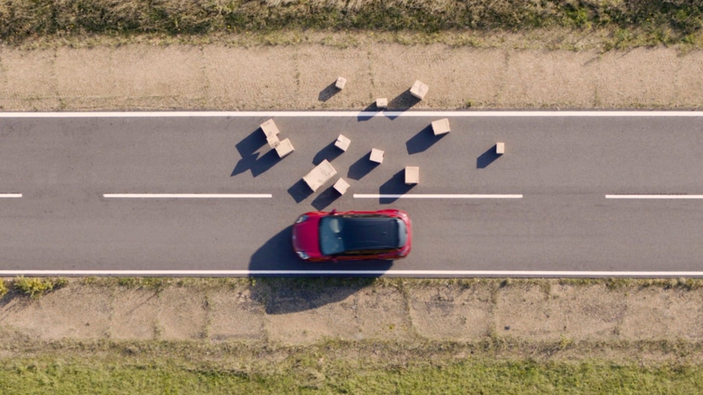 Ford Kuga in Rot. Auf einer Landstrasse Hindernissen ausweichend