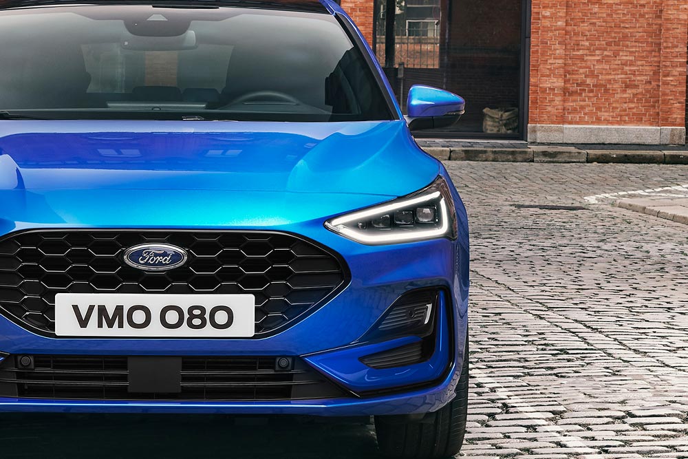Frontansicht eines blauen Ford Focus, wobei die Scheinwerfer und der Kühlergrill hervorgehoben werden.