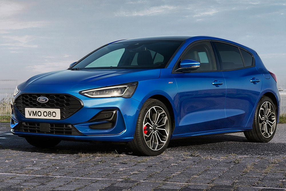 Ein blauer Ford Focus ST-Line Schrägheck mit roten Bremssätteln, geparkt auf einer gepflasterten Fläche.