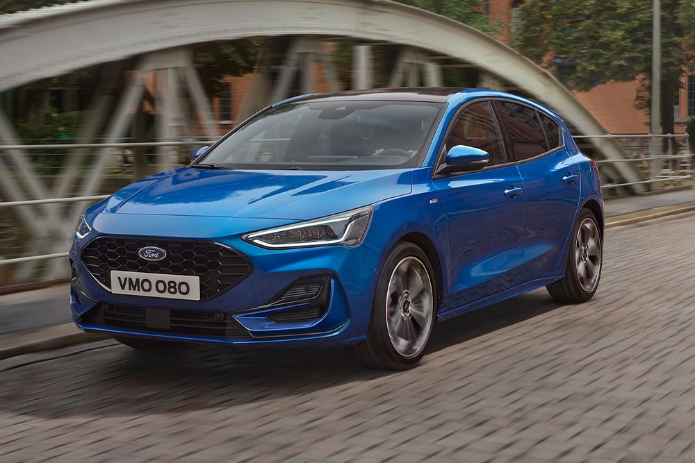Ein blauer Ford Focus Schrägheck fährt über eine Brücke.