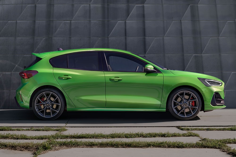 Ein Ford Focus ST in Mean Green Schrägheck steht seitlich, abseits der Strasse.
