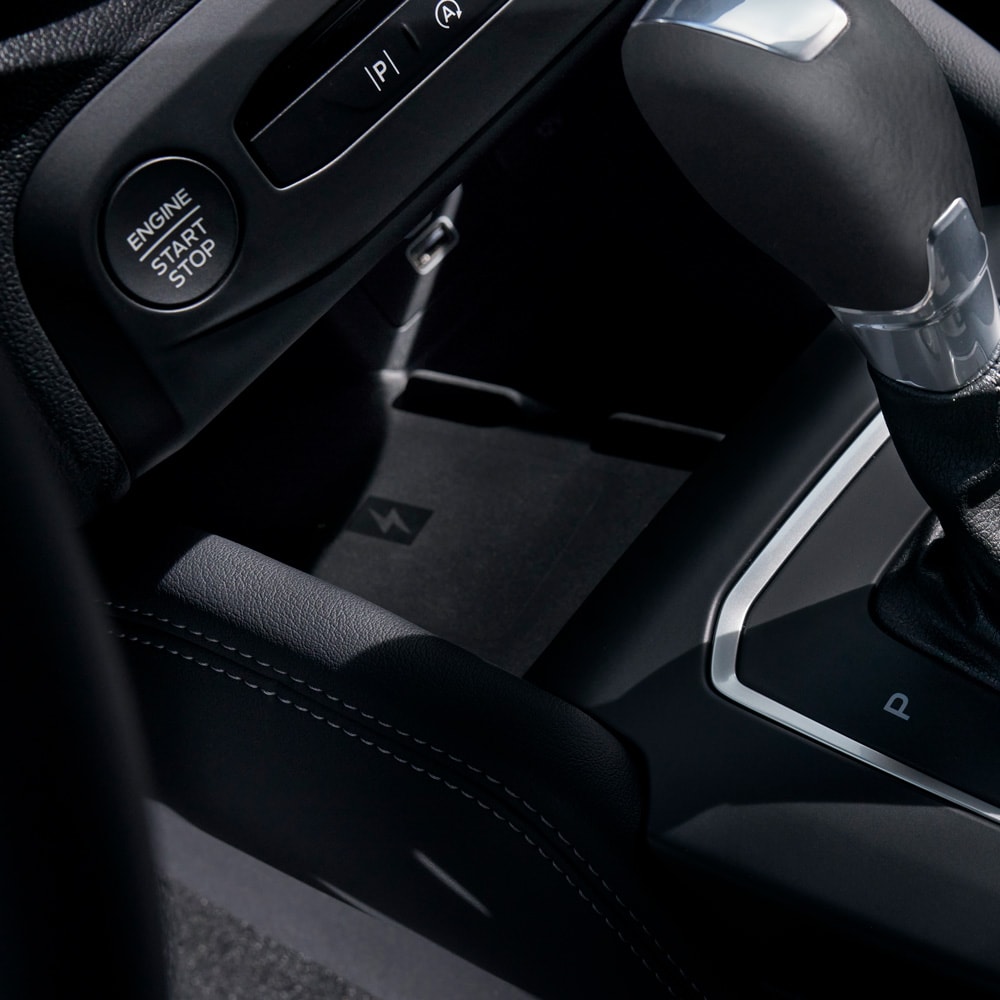 Nahaufnahme des Ford Focus Innenraums mit kabelloser Ladefunktion für Handys hinter dem Schalthebel.