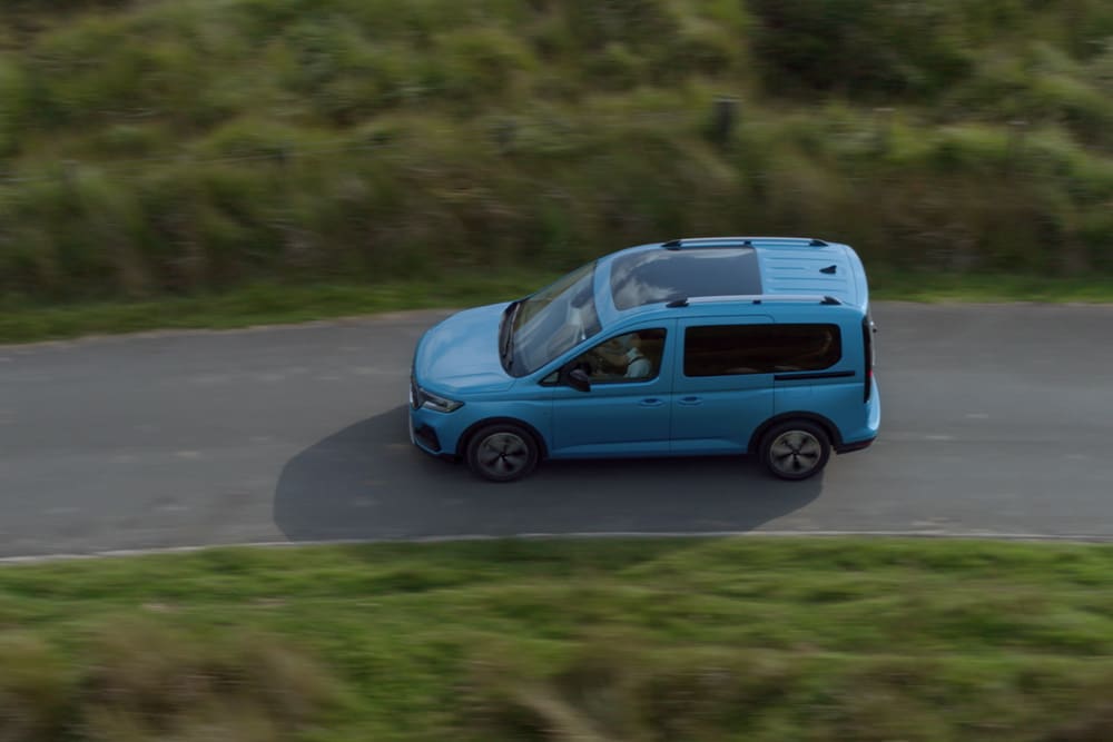 Ford Tourneo Connect in Hellblau Seitenansicht in der Vogelperspektive fährt auf Landstrasse