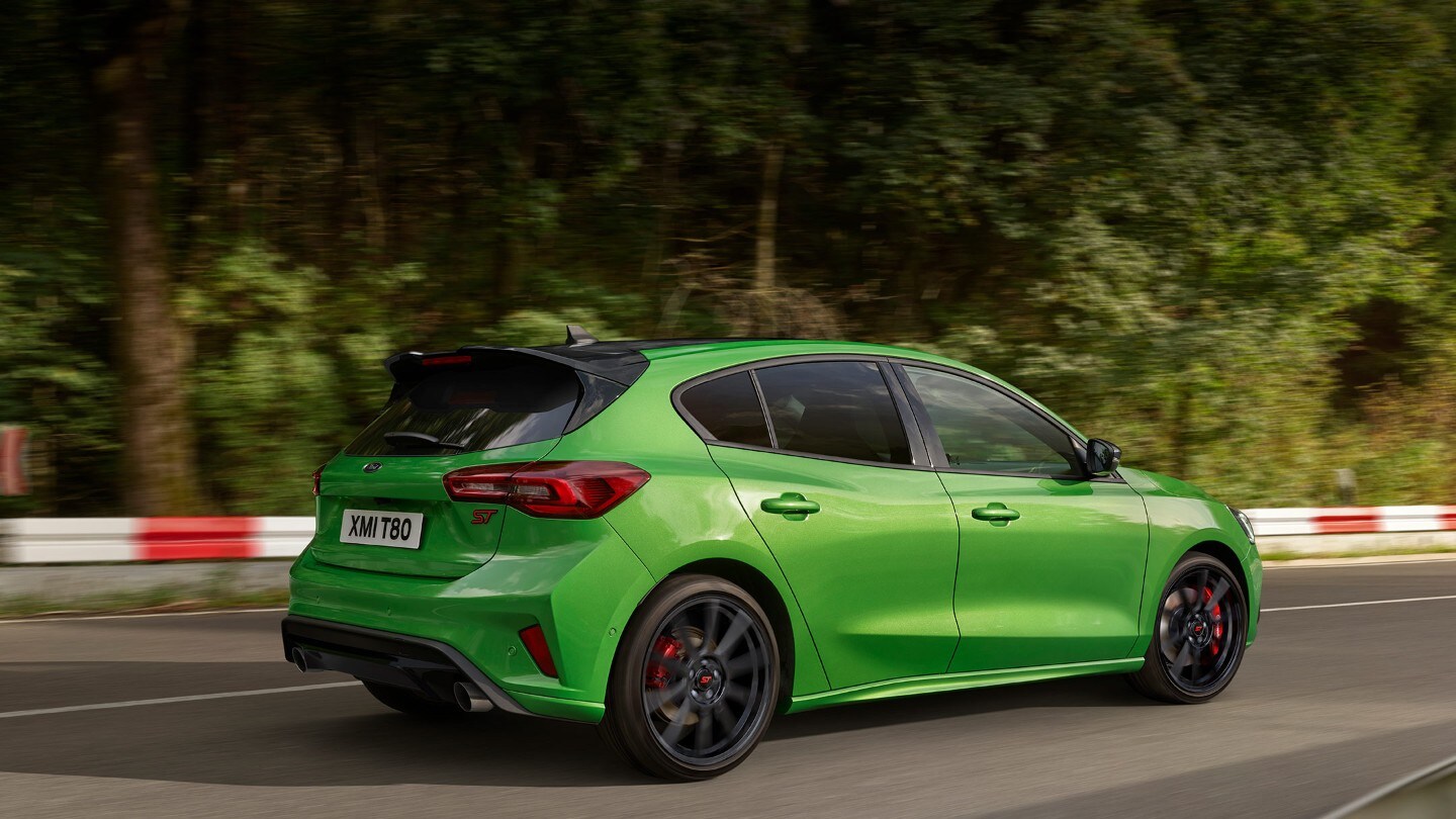 Ford Focus ST in Grün. Dreiviertel-Rückansicht, auf einer Strasse fahrend.