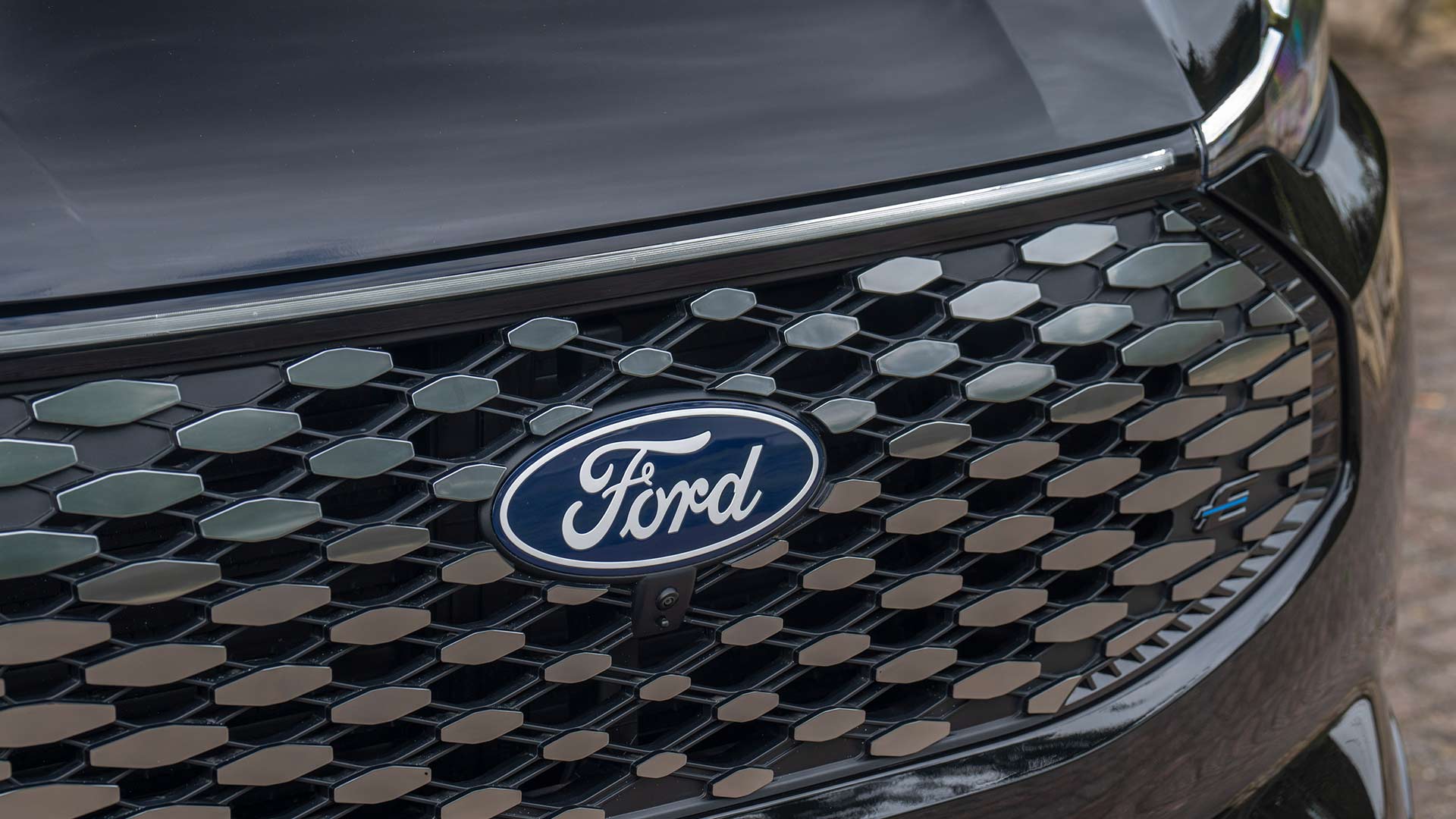 Nahaufnahme des Ford Logos und des Mustergrills beim Ford E-Tourneo Custom