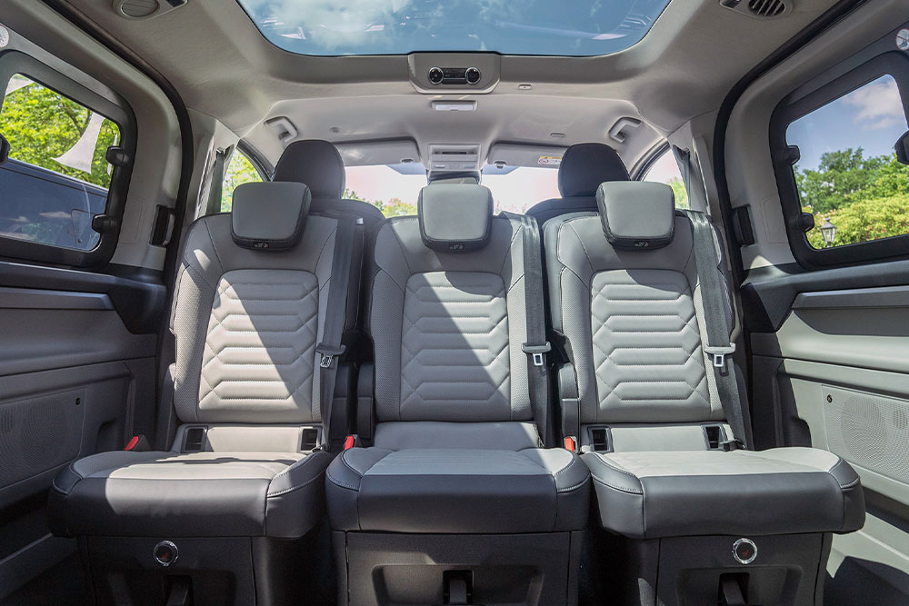 Innenansicht eines Fahrzeugs mit grauen Rücksitzen und Schiebedach