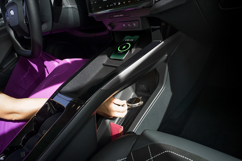 Nahaufnahme, die das kabellose Laden und den Stauraum des Ford Puma Gen-E® demonstriert. 
