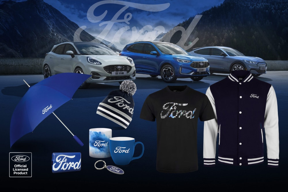 Ford Merchandise-Kollektion mit verschiedenen Ford-Fahrzeugen im Hintergrund sowie Regenschirm, Tassen und Kleidungsstücken mit Ford-Branding.