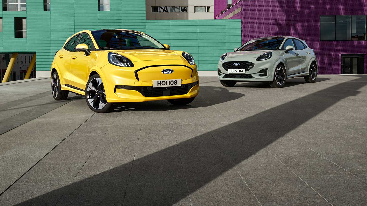 Ein vollelektrischer Ford Puma Gen-E® in Gelb ist neben einem grauen Ford Puma® mit EcoBoost®-Benzinmotor parkiert. 