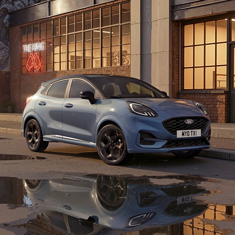 Ein Ford Puma in der Sonderfarbe Vapour Blue , der auf einer schwach beleuchteten Stadtstrasse geparkt ist.