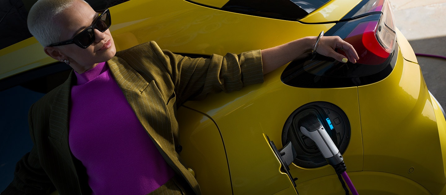 Nahaufnahme vom Heck eines elektrischen Ford Puma Gen-E®, der an eine Wallbox angeschlossen ist.
