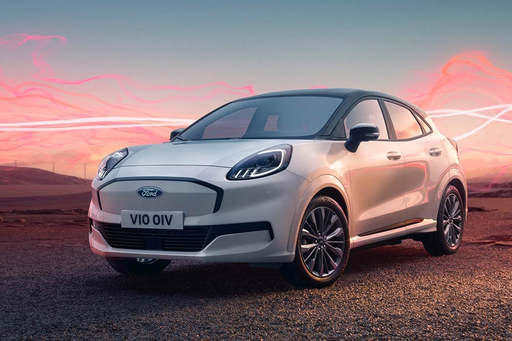 Ford Puma Gen-E Sound Edition in weiss, parkend mit roter Schallwellengrafik im Hintergrund.