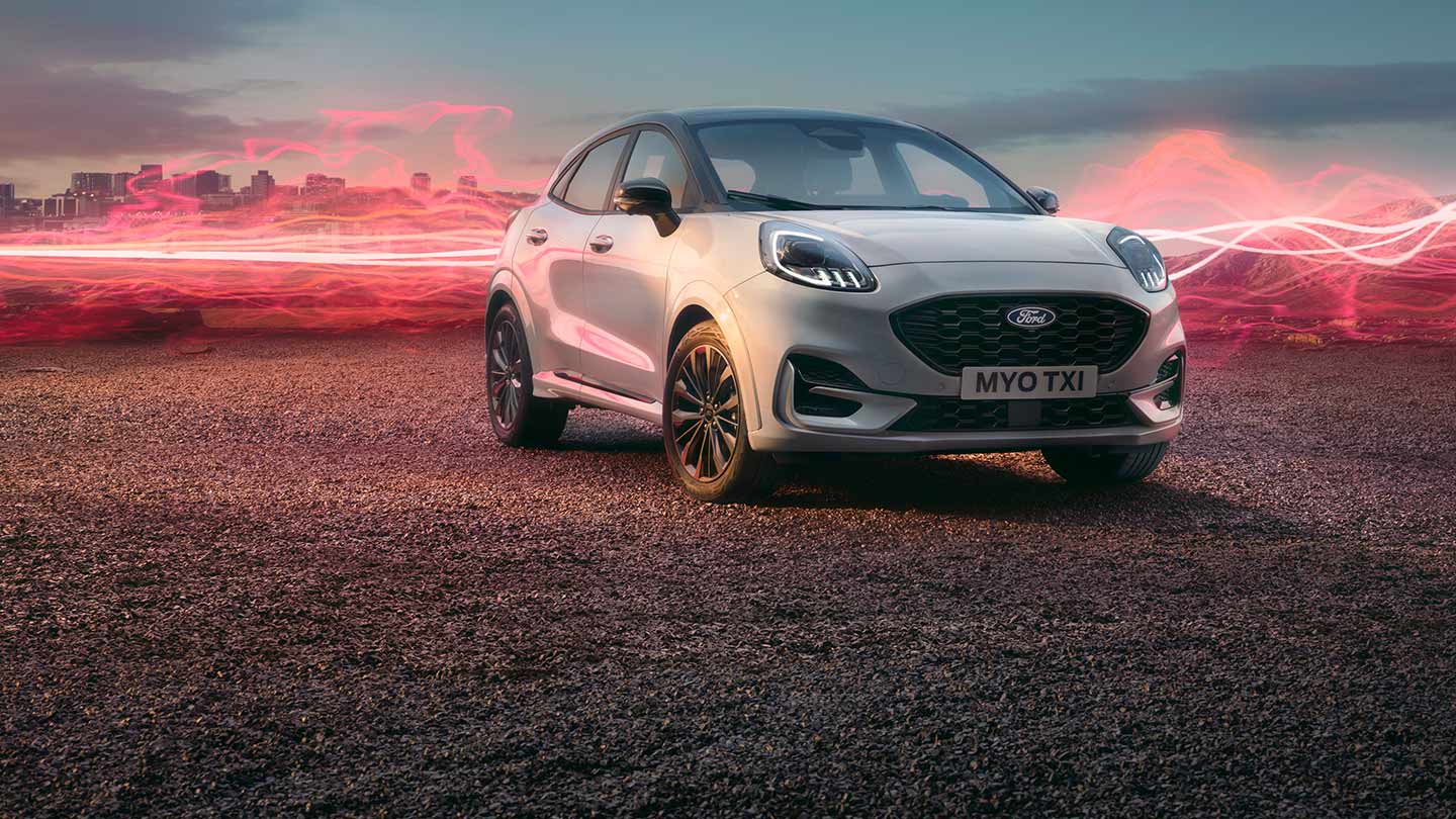 Ford Puma Sound Edition in weiss, parkend mit roter Schallwellengrafik im Hintergrund.