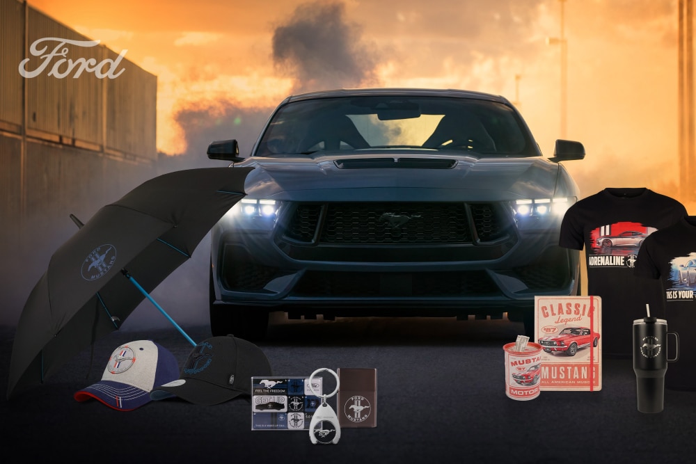 Eine Grau getönte Ford Mustang Kollektion mit einem grauen Mustang im Hintergrund sowie Fanartikeln wie Schirm, Cappy, Tassen und T-Shirts.