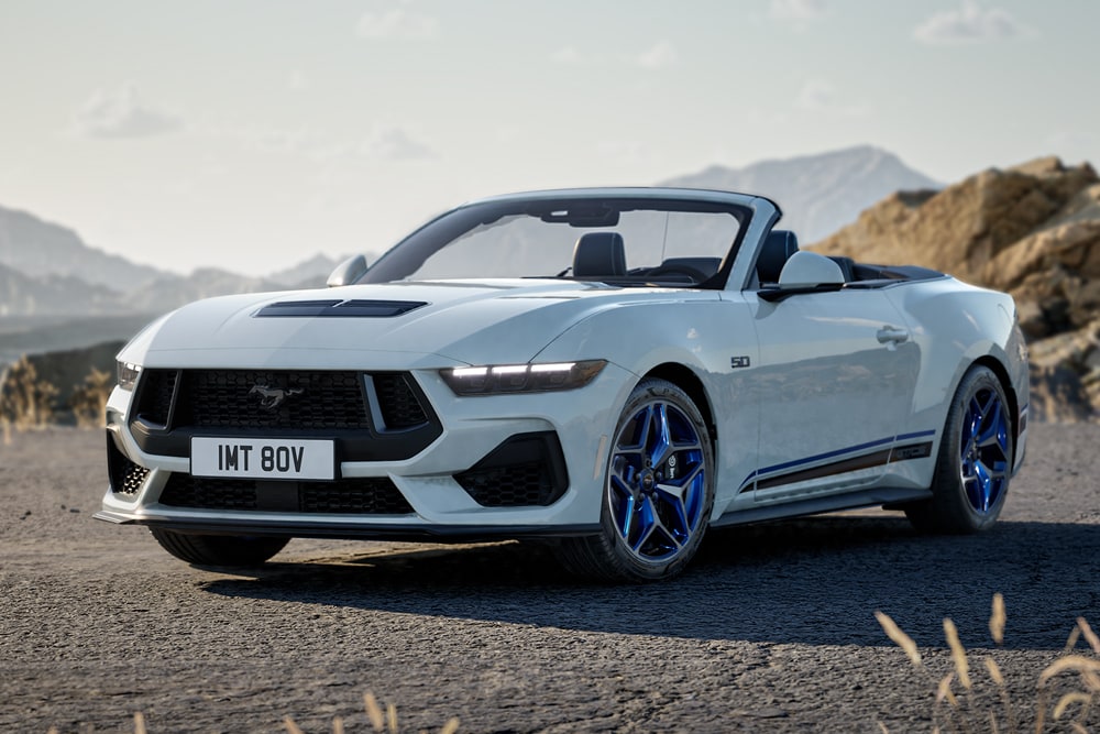 Seitenansicht eines weissen Ford Mustang California Special, der auf einer Bergstrasse fährt