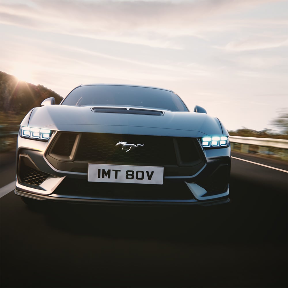 Ein grauer Ford Mustang, der um eine Kurve fährt