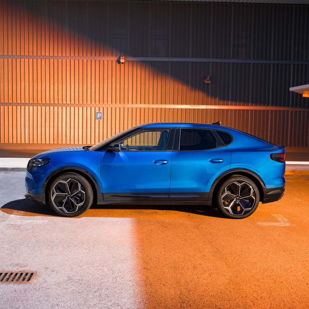 Eine Seitenansicht eines blauen Ford Capri. Die 5-Sterne-Sicherheitsbewertung von Euro NCAP für 2024 wird in der oberen rechten Ecke angezeigt.