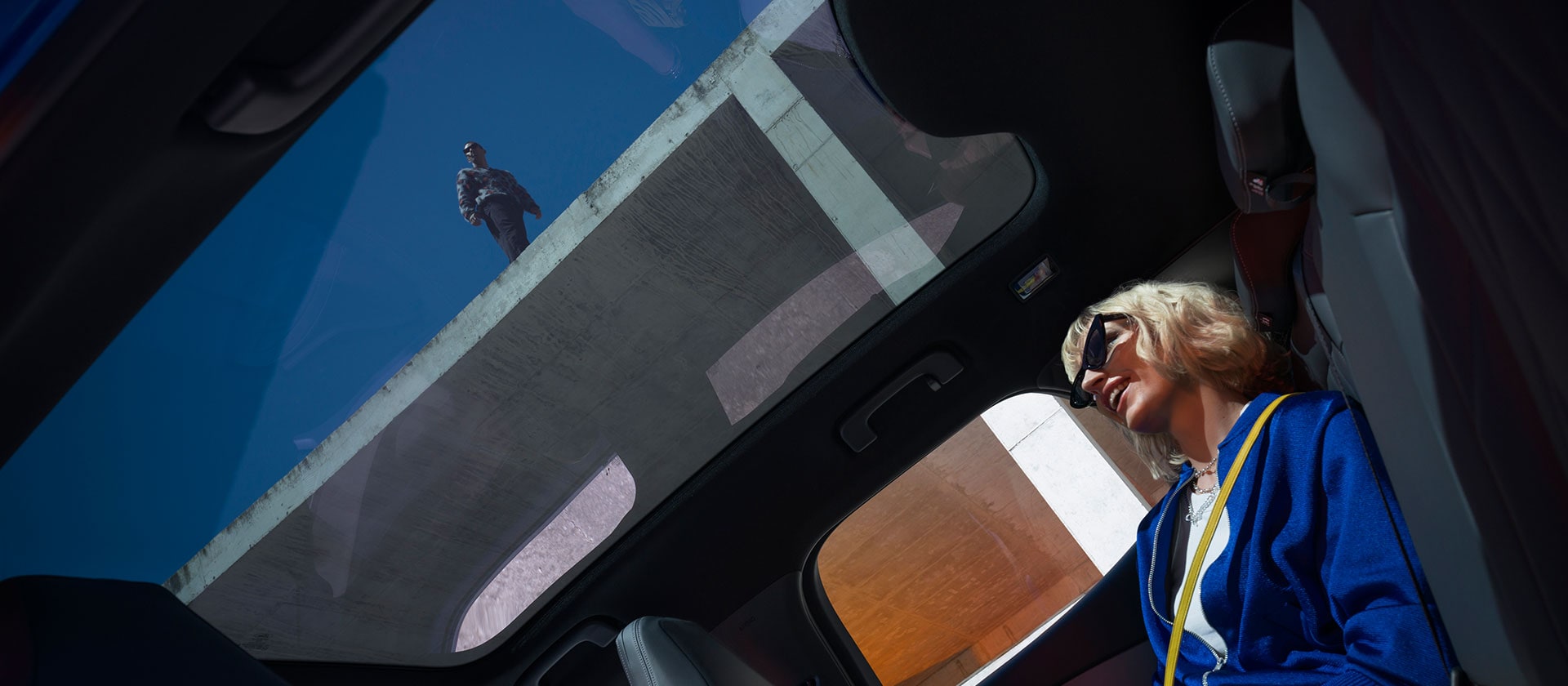 Eine Person sitzt in einem neuen Ford Capri® und geniesst das Panoramadach.