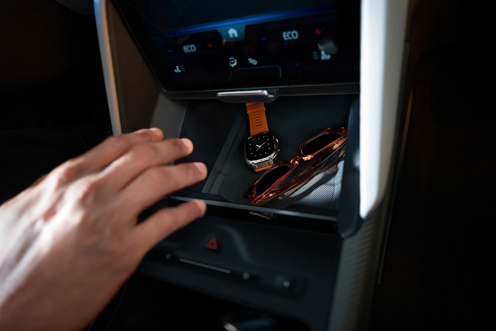 Eine Hand greift nach dem Fach „My Private Locker“ im Ford Capri®. Darin sind eine Uhr und eine Sonnenbrille zu sehen.
