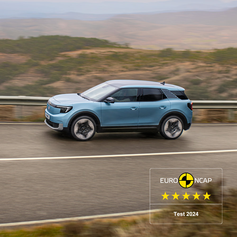 Ein blauer Ford Explorer, der eine Bergstrasse entlangfährt, mit dem Fünf-Sterne-Logo 2024 von Euro-NCAP in der oberen linken Ecke.