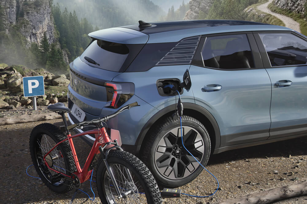 Ein E-Bike, das von einem Ford Explorer® geladen wird, bergige Landschaft im Hintergrund.