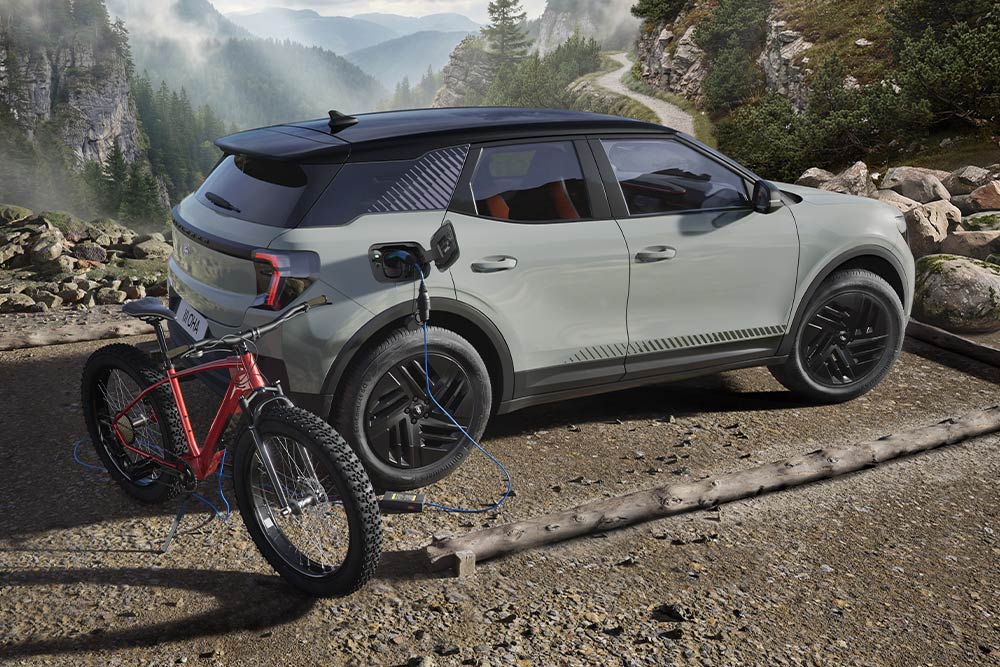 Ein E-Bike, das von einem Ford Explorer® geladen wird, bergige Landschaft im Hintergrund.