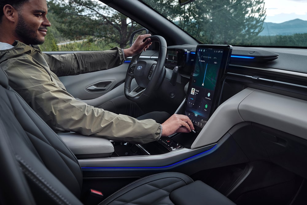 Der Fahrer bedient das Touchscreen-Infotainmentsystem im Familien-SUV Ford Explorer.