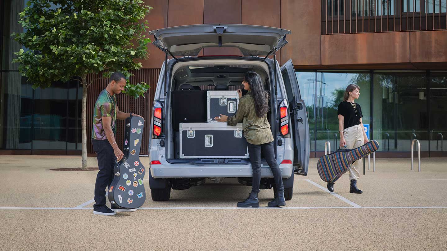 Personen, die Gepäck hinten im brandneuen Tourneo Custom verstauen