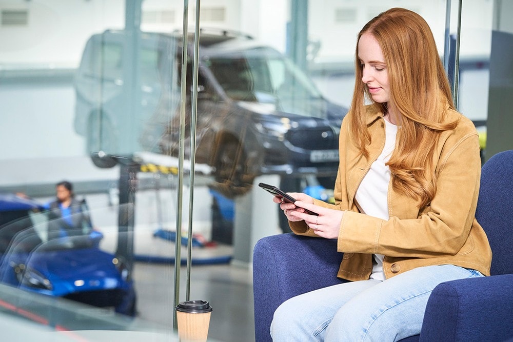 Ein Mann, der an einem Tisch mit einem Laptop und Handy in einem modernen Büro sitzt