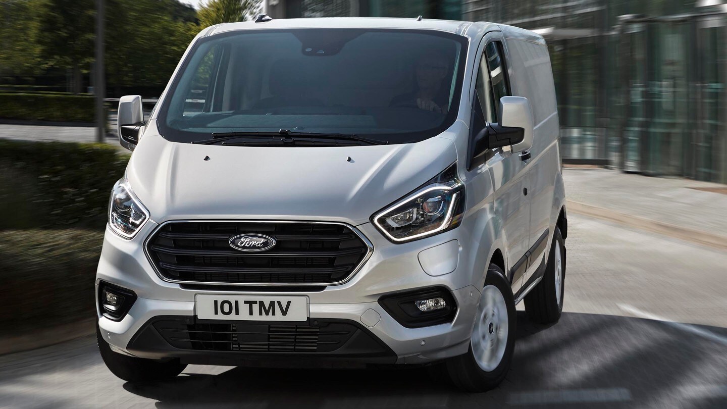 Ford Transit  Custom Kastenwagen LKW Plug-in-Hybrid Silber ¾-Frontansicht in Bewegung auf Strasse