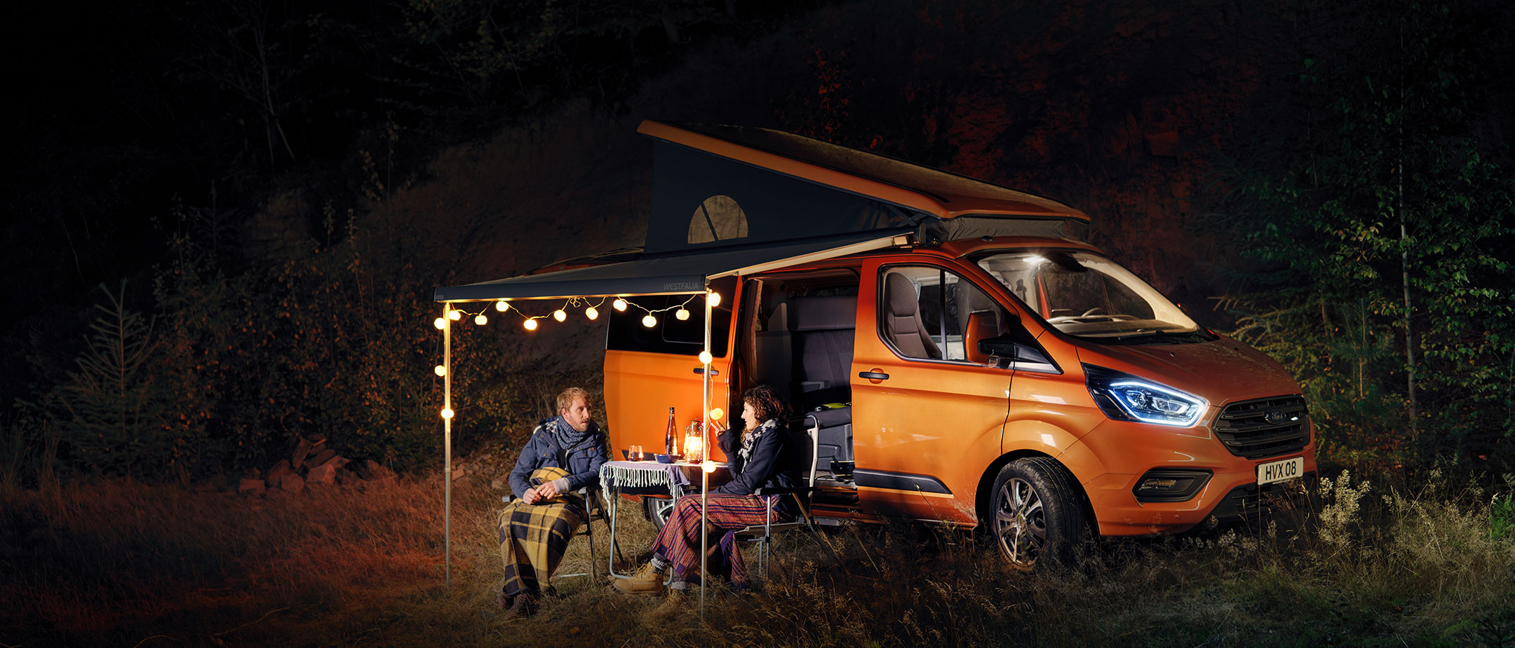 New Orange Ford Transit Custom Nugget with couple camping