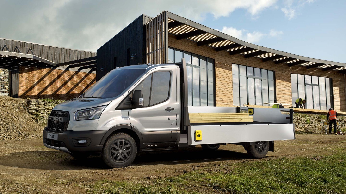 Ford Transit Pritschenwagen Silber Seitenansicht beladen parkt auf Baustelle