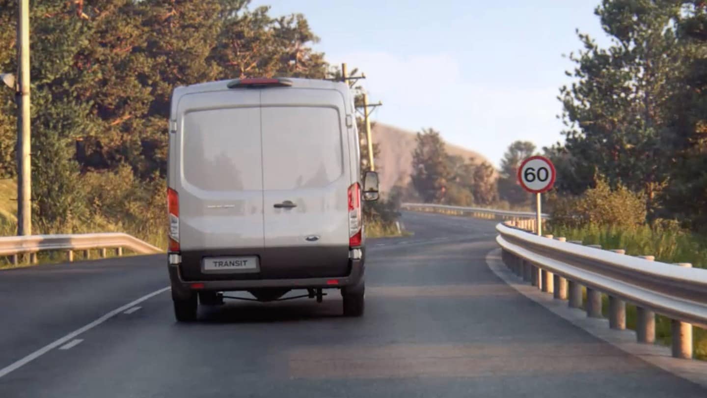 Ford Transit Van fährt auf der Strasse mit Verkehrsschild von hinten