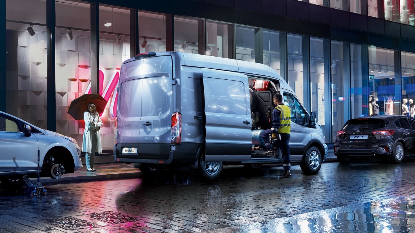 Service person standing by Ford Transit Van