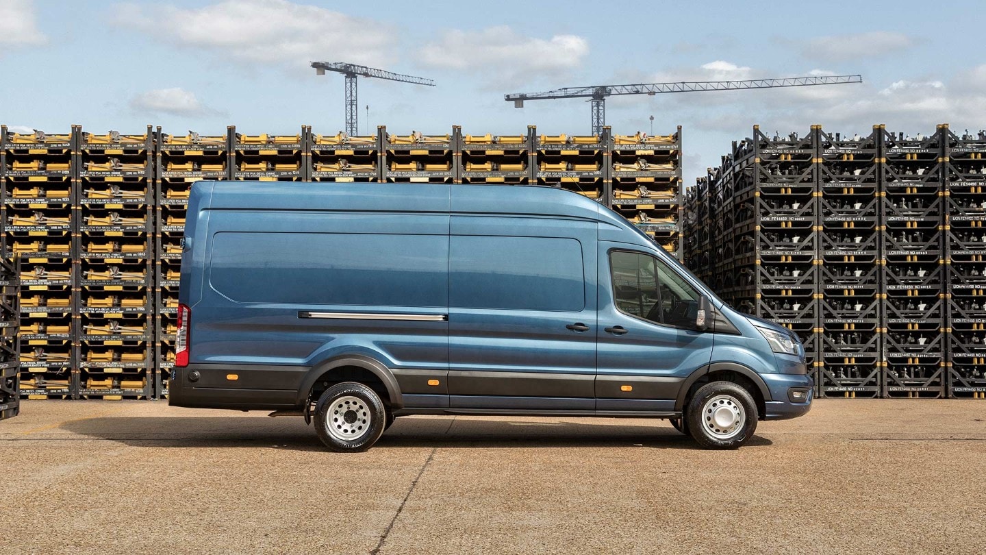 Ford Transit 5 Tonnen Kastenwagen LKW in Blau Seitenansicht parkt auf Betriebsgelände vor Palettenstapeln