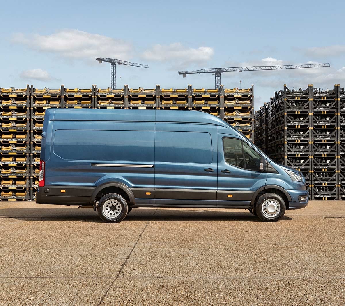 Ford Transit 5 Tonnen Kastenwagen LKW in Blau Seitenansicht parkt auf Betriebsgelände vor Palettenstapeln