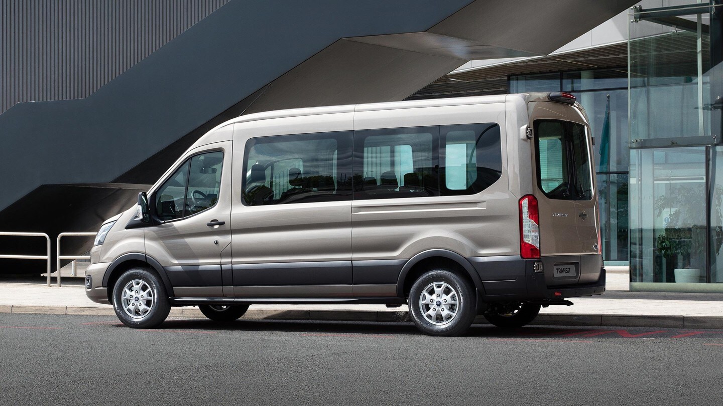 Ford Transit Kombi PKW silber Seitenansicht parkt vor modernem Gebäude