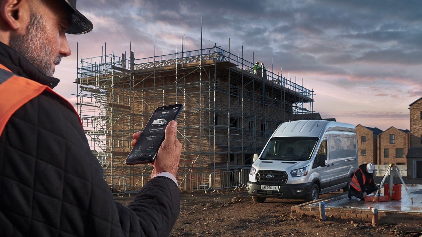 Bauarbeiter hält Smartphone in der Hand